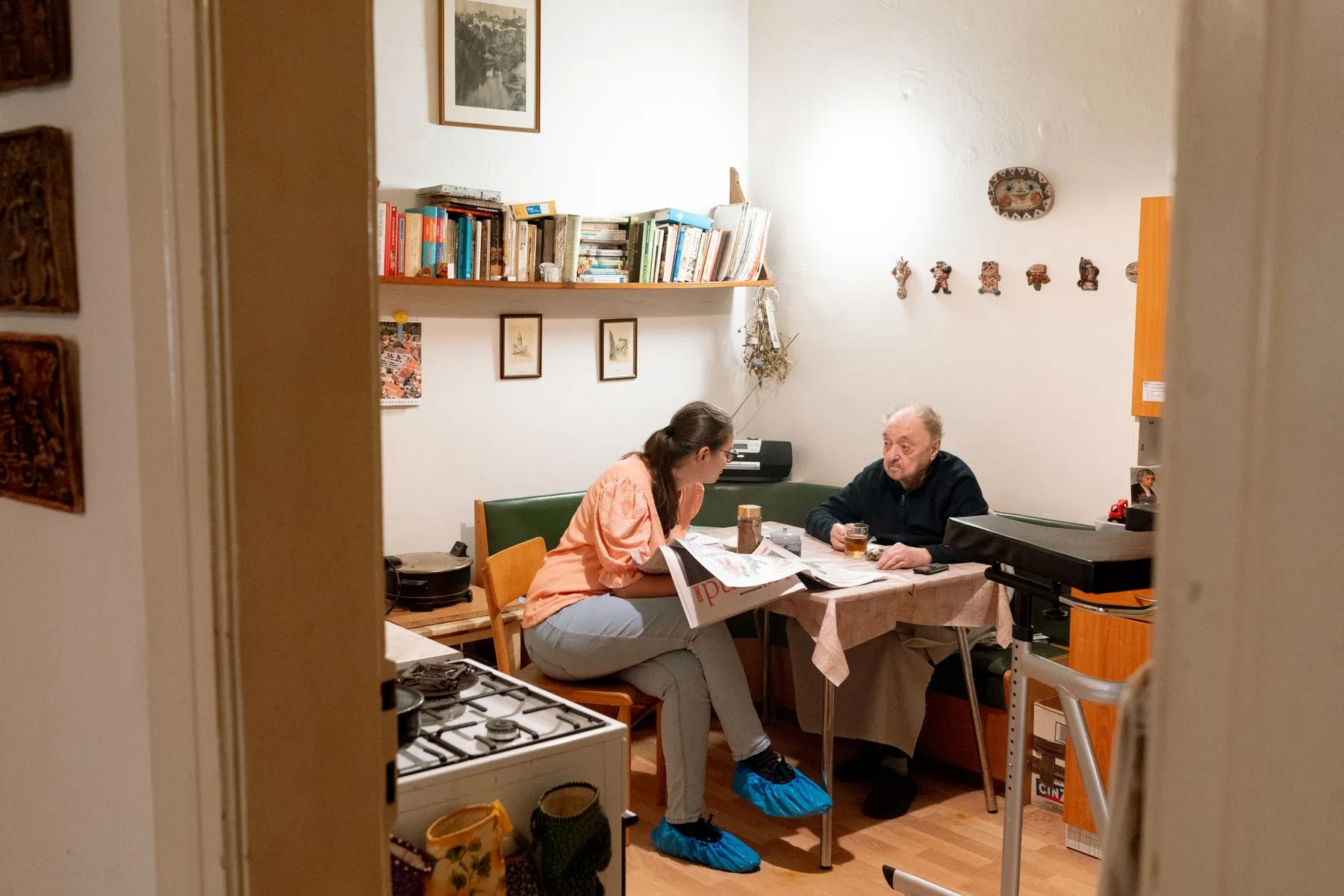 Two people sharing a cup of tea and a chat at a kitchen table