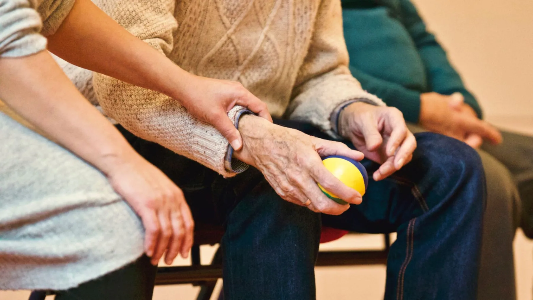 A younger hand gently holding an older person's hand