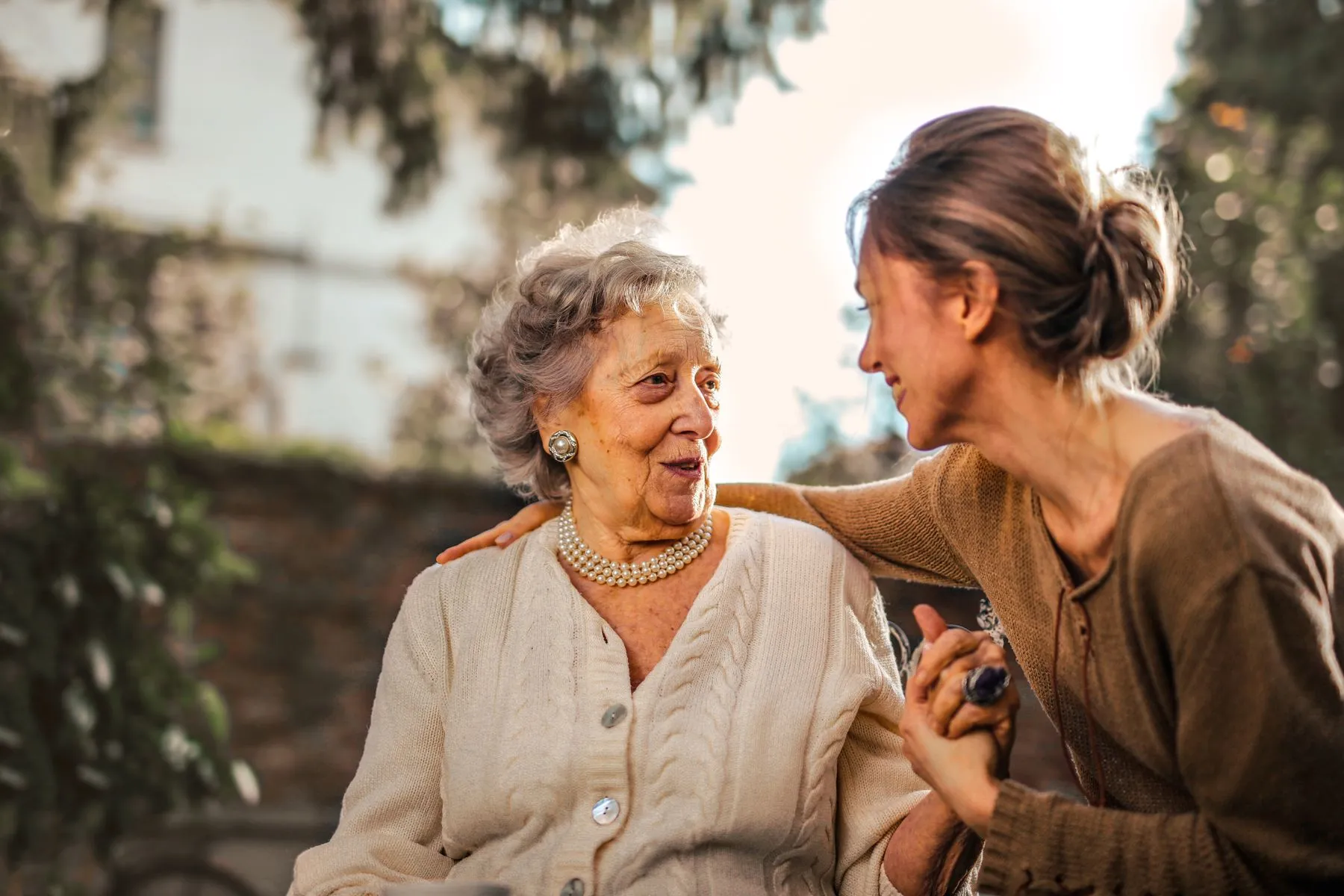 A carer and an older woman laughing together at home